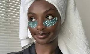Donna con turbante e cerotti occhi, un tocco di retinolo naturale per una pelle radiosa.