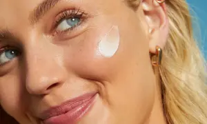 Primo piano di una donna con crema sul viso. L'acido salicilico per la pelle aiuta a ottenere un incarnato luminoso e uniforme.