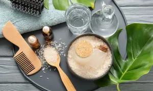 Ingredienti naturali per la cura dei capelli: riso, acqua, oli essenziali, pettine e spazzola. L'acqua di riso capelli è un segreto di bellezza.
