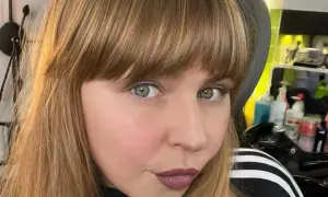 Ragazza con capelli castani e una frangia che incornicia il viso. Sguardo intenso e labbra color prugna.