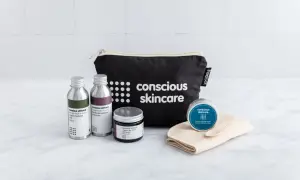 Kit skincare viso con borsa nera, flaconi, crema e maschera.