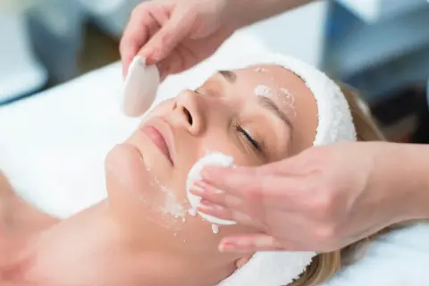 Una donna riceve un trattamento viso. La frequenza ideale per la pulizia del viso dipende dal tipo di pelle.