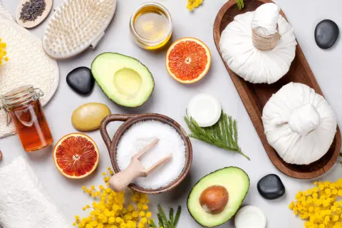 Ingredienti per uno scrub fatto in casa: sale, avocado, arancia, miele, lavanda e una spazzola per il corpo.