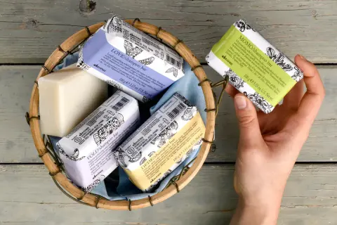 Scopri come si usa lo shampoo solido Davines: una mano sceglie una saponetta profumata da un cesto.