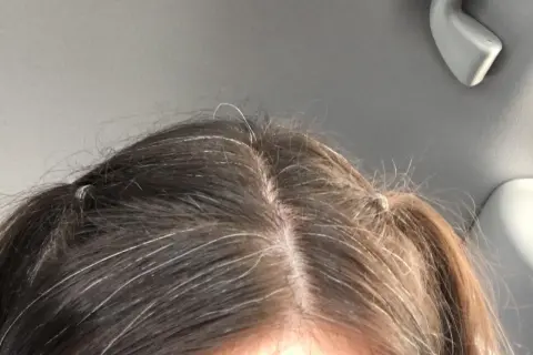 Capelli scuri con fili bianchi evidenti. La ricrescita è visibile, segno che si può fare la tinta ogni 15 giorni per un look sempre curato.
