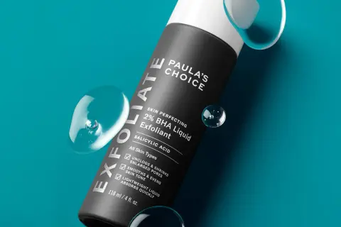 Flacone di esfoliante viso Paula's Choice 2% BHA Liquid Exfoliant, con gocce d'acqua. Scopri come si usa per una pelle levigata.