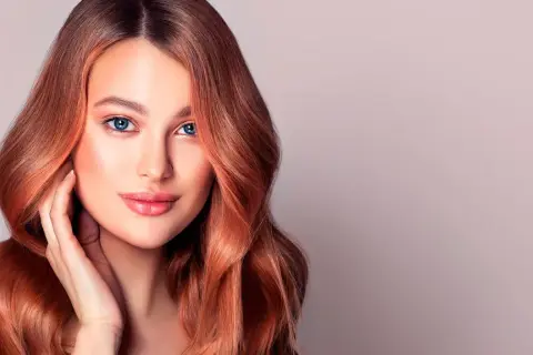 Donna con capelli ramati luminosi, un esempio perfetto di tonalità rosso capelli tabella.