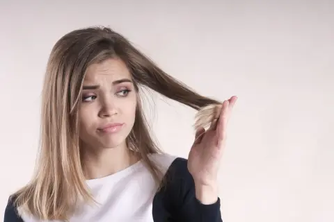 Ragazza preoccupata per le doppie punte, si chiede perché i capelli crescono lentamente.