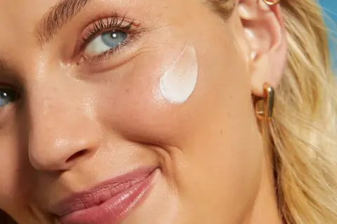 Primo piano di una donna con crema sul viso. L'acido salicilico per la pelle aiuta a ottenere un incarnato luminoso e uniforme.
