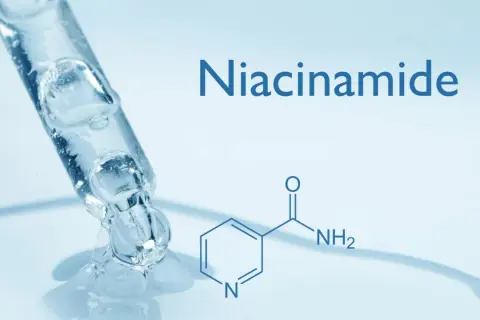 Goccia di siero trasparente da un contagocce, con la formula chimica e il nome "Niacinamide" che indica cos'è la niacinamide.
