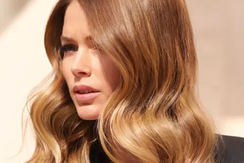 Capelli con sfumature ombré, onde morbide e un look naturale che cattura la luce.