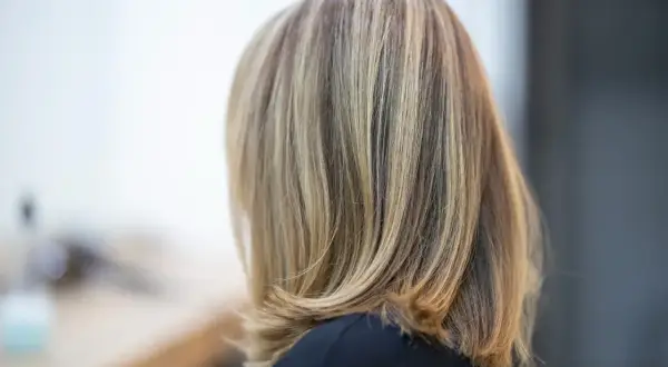 Capelli mossi con sfumature di biondo cenere naturale, un look sofisticato e luminoso.