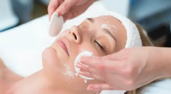 Una donna riceve un trattamento viso. La frequenza ideale per la pulizia del viso dipende dal tipo di pelle.