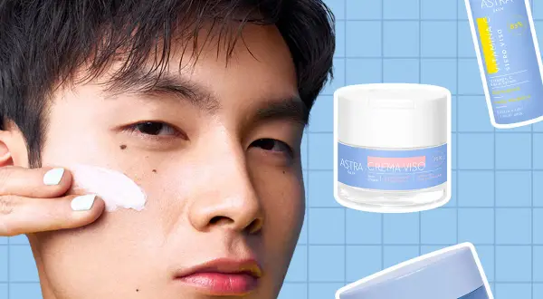 Un uomo applica una crema viso. Accanto, i prodotti Astra: siero viso Vitamina C e crema viso. La domanda è: si mette prima il siero o la crema?