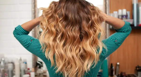 Capelli mossi con sfumature biondo caldo, un look radioso che cattura la luce.