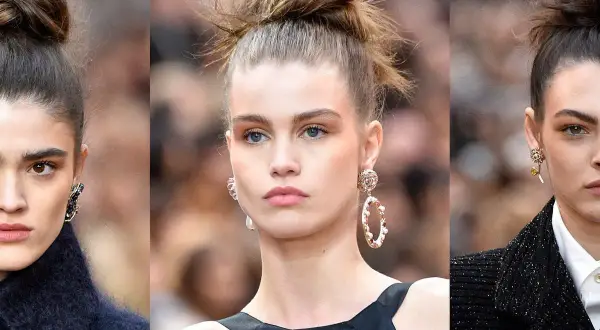 Tre modelle con un elegante chignon capelli, orecchini vistosi e makeup naturale.