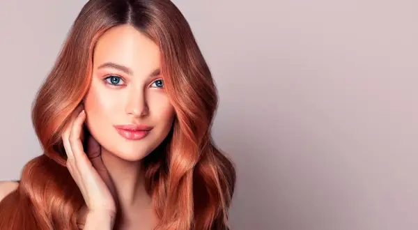 Donna con capelli ramati luminosi, un esempio perfetto di tonalità rosso capelli tabella.