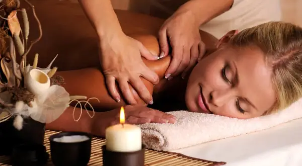 Donna rilassata riceve un massaggio total body, godendo dei suoi benefici per il benessere e il relax.