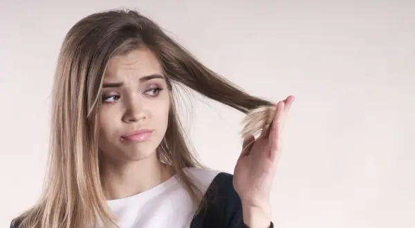 Ragazza preoccupata per le doppie punte, si chiede perché i capelli crescono lentamente.
