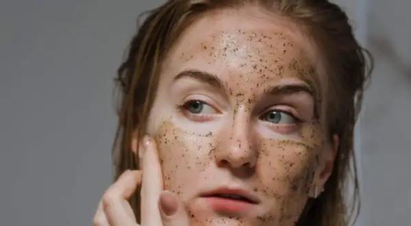 Ragazza con scrub sul viso, un gesto di cura per capire quante volte fare lo scrub viso per una pelle luminosa.