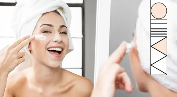 Donna sorridente con turbante, applica crema viso. Un rituale di bellezza per un perfetto ordine skincare.