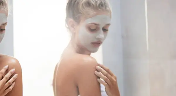 Donna con maschera viso, un rituale di bellezza prima o dopo la doccia per una pelle radiosa.