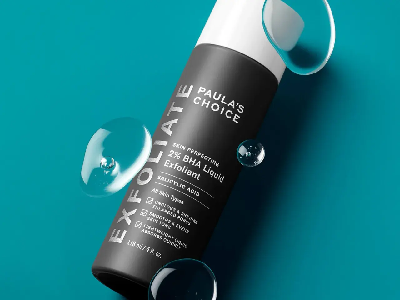 Flacone di esfoliante viso Paula's Choice 2% BHA Liquid Exfoliant, con gocce d'acqua. Scopri come si usa per una pelle levigata.