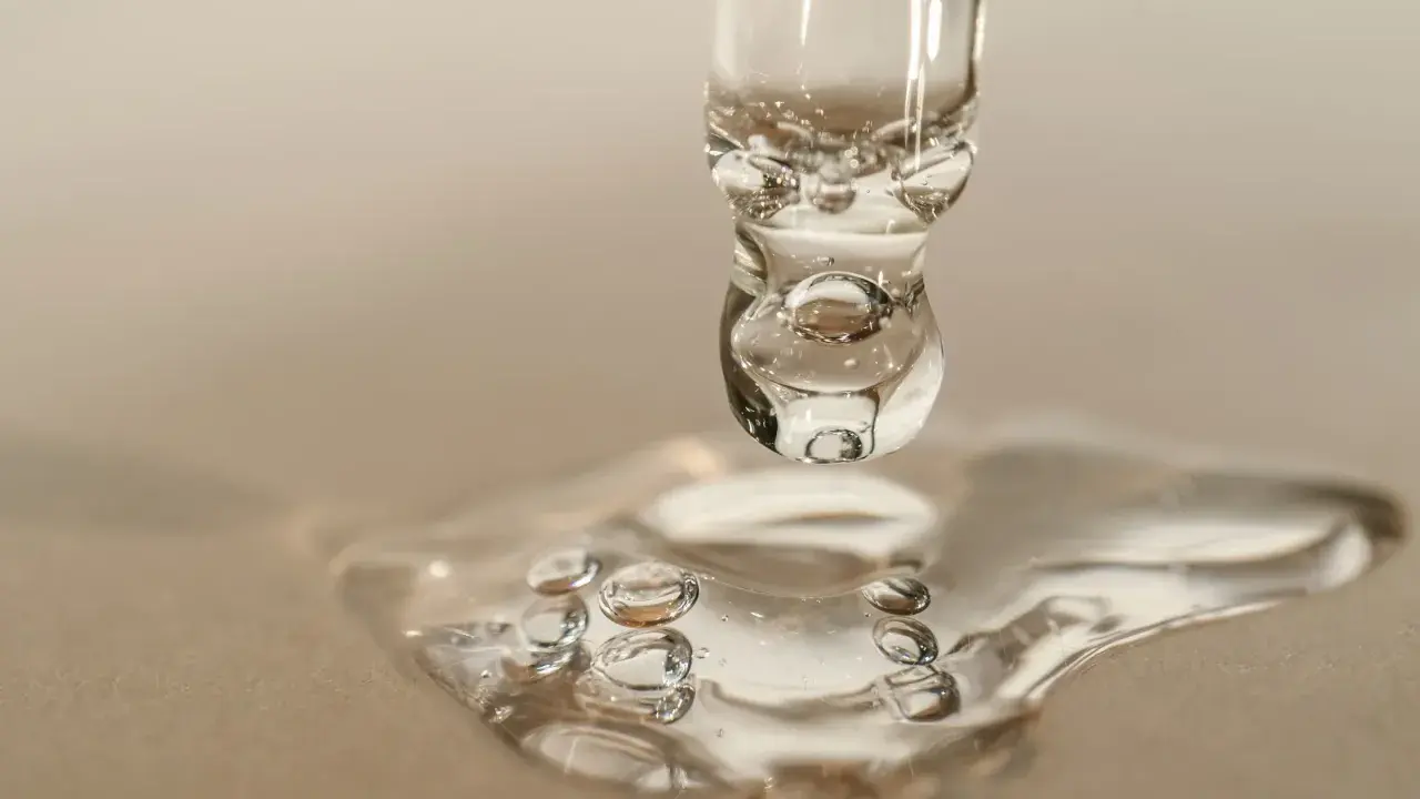 Goccia di siero con retinolo, che riflette la luce come il sole. La sua consistenza trasparente e le bollicine catturano l'essenza della cura della pelle.