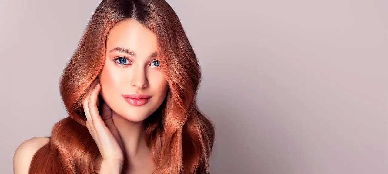Donna con capelli ramati luminosi, un esempio perfetto di tonalità rosso capelli tabella.