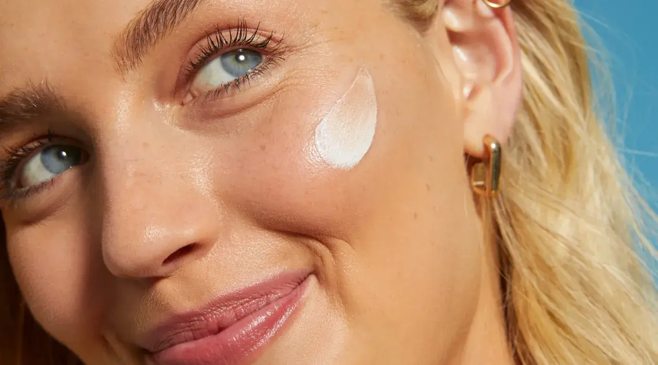 Primo piano di una donna con crema sul viso. L'acido salicilico per la pelle aiuta a ottenere un incarnato luminoso e uniforme.
