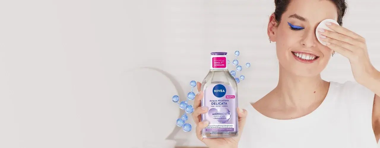 Donna sorridente rimuove il trucco con acqua micellare Nivea, mostrando come si usa acqua micellare per una pulizia delicata.