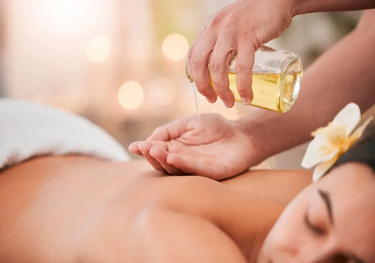 Un massaggio total body per godere di tutti i suoi benefici. Olio caldo versato su una mano pronta per un momento di puro relax.