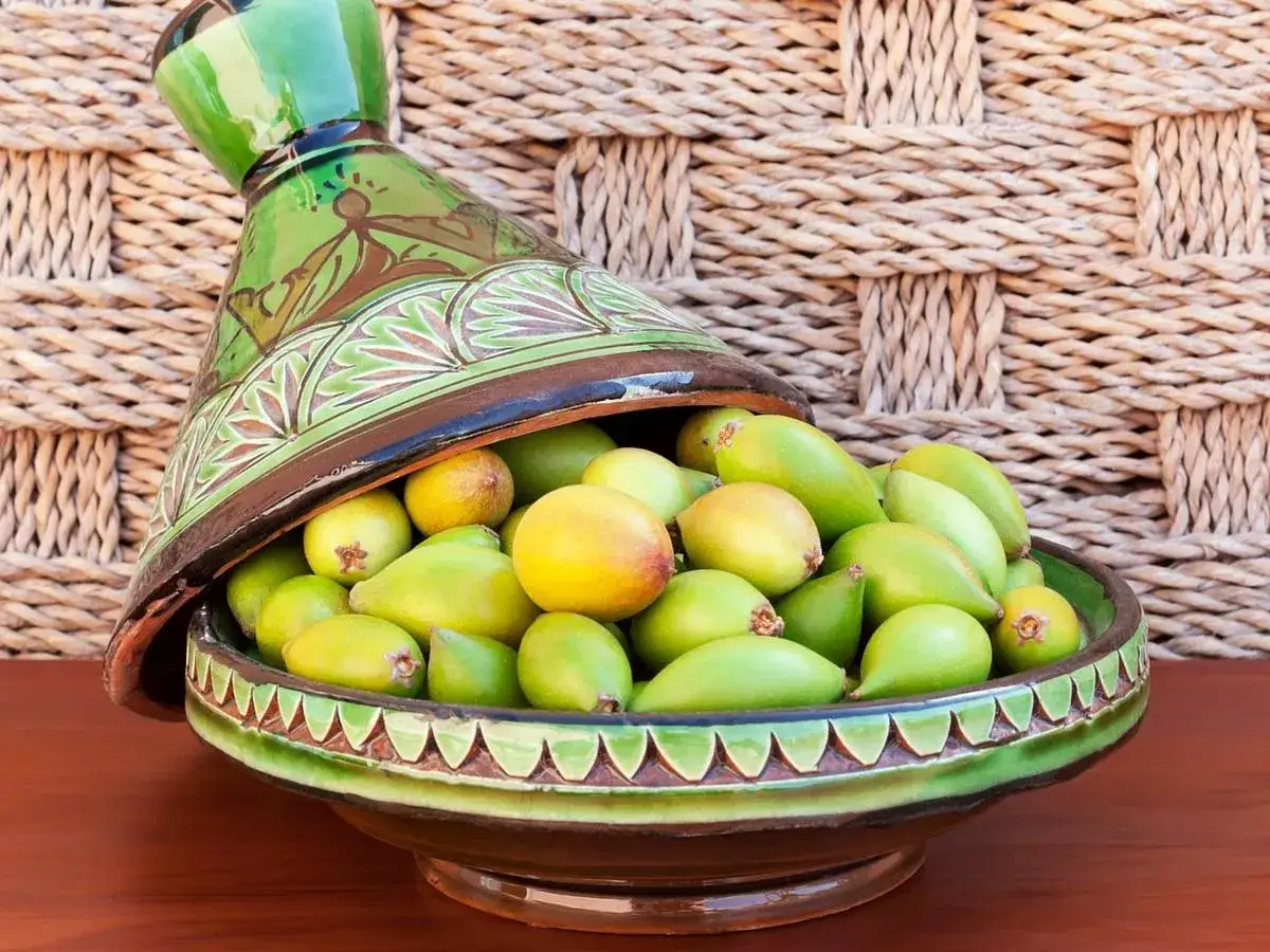 Frutti di argan in un tagine decorato. Questi frutti verdi e gialli sono la fonte dell'olio di argan, un tesoro del Marocco.