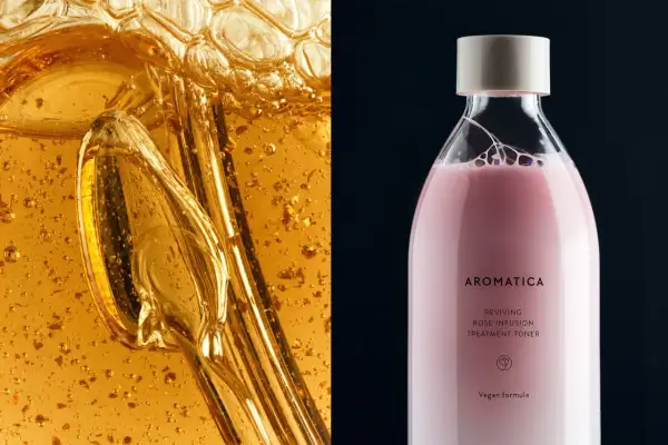 Dettaglio di un liquido dorato e viscoso con bollicine e un flacone di tonico rosa AROMATICA. La niacinamide è fotosensibilizzante.