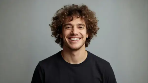 Uomo sorridente con splendidi capelli ricci uomo, un look naturale e vivace.