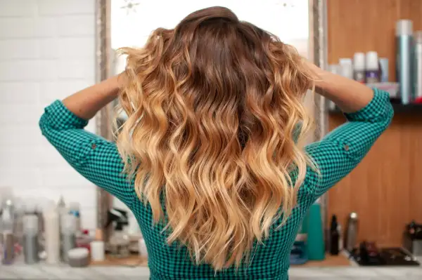 Capelli mossi con sfumature biondo caldo, un look radioso che cattura la luce.