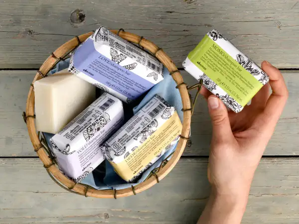 Scopri come si usa lo shampoo solido Davines: una mano sceglie una saponetta profumata da un cesto.