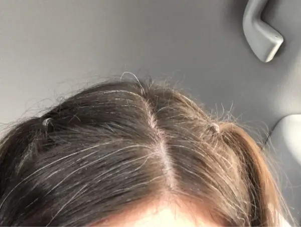 Capelli scuri con fili bianchi evidenti. La ricrescita è visibile, segno che si può fare la tinta ogni 15 giorni per un look sempre curato.
