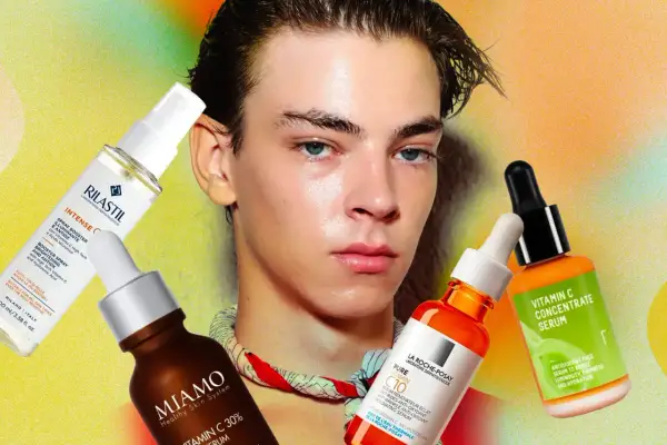 Un ragazzo con pelle luminosa mostra diversi sieri alla vitamina C, ideali anche per l'estate.